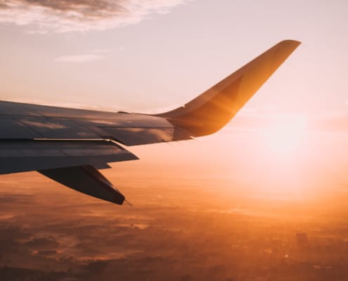 Sunset view from an airplane window, symbolizing a South African expat's journey abroad for tax planning.